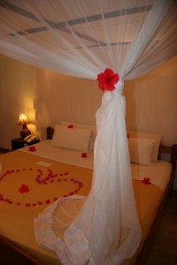 Our bed decorated with fresh flowers from Mapenzi Beach Resort.