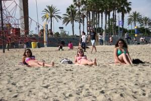 Hailey, Lexi, and Brittney tanning on the beach.
